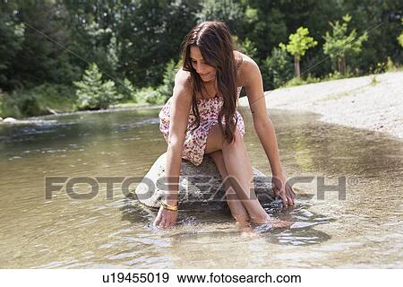 Teenage girl sitting on rock in stream View Large Photo Image Stock Photo - Teenage girl sitting on rock in stream. Fotosearch