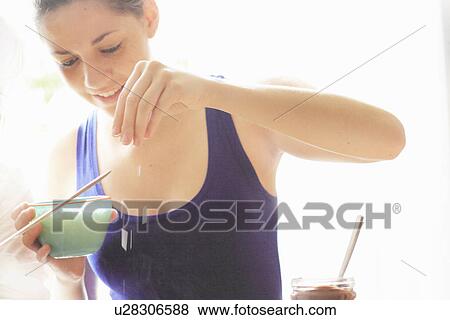 Stock Photo - Teenage girl sprinkling salt on food. Fotosearch