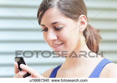 Stock Image - Teenage girl using cell phone. Fotosearch