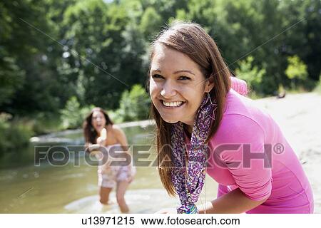 Stock Photography - Teenage girls playing in rural stream. Fotosearch