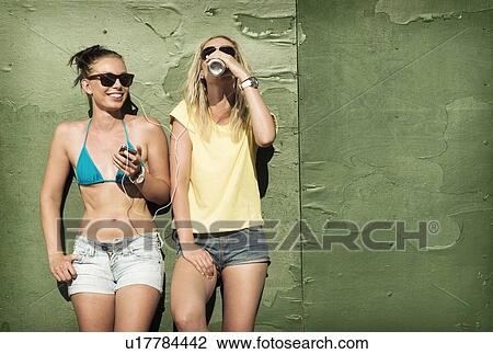 Teenage girls sharing headphones View Large Photo Image Stock Image - Teenage girls sharing headphones. Fotosearch