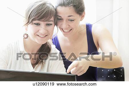 Teenage girls using laptop together View Large Photo Image Stock Photo - Teenage girls using laptop together. Fotosearch
