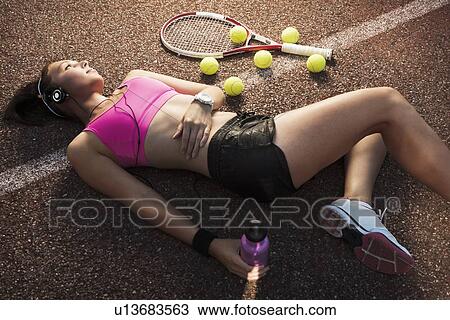 Stock Image - Tennis player laying on court. Fotosearch