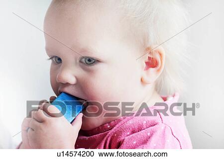 Toddler chewing on toy block View Large Photo Image Stock Image - Toddler chewing on toy block. Fotosearch