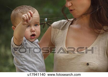 Stock Image - Toddler playing with mothers necklace. Fotosearch