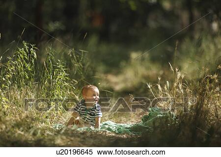 Toddler sitting on blanket in field View Large Photo Image Stock Photography - Toddler sitting on blanket in field. Fotosearch