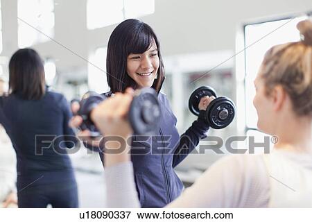 Stock Photo - Trainer working with client in gym. Fotosearch