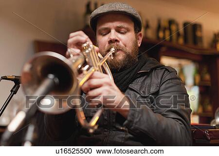 Stock Image - Trumpet player playing into microphone. Fotosearch