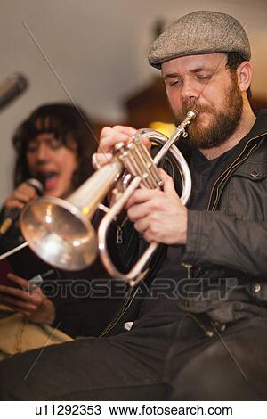 Stock Image - Trumpet player practicing with band. Fotosearch