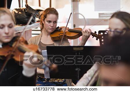 Stock Photo - Violin player practicing with group. Fotosearch