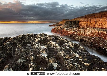 Stock Photo - Waves washing up on rock formations. Fotosearch