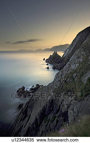 Stock Photography - Waves washing up on rocky coastal cliffs. Fotosearch