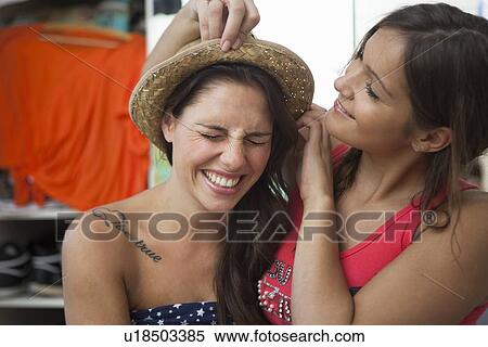 Woman adjusting friends hat in bedroom View Large Photo Image Stock Photography - Woman adjusting friends hat in bedroom. Fotosearch
