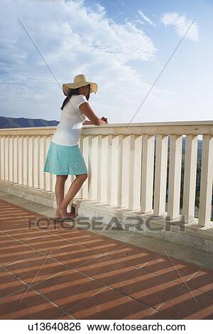 Woman admiring view from balcony View Large Photo Image Stock Photograph - Woman admiring view from balcony. Fotosearch