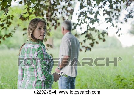 Woman and father standing in grass View Large Photo Image Picture - Woman and father standing in grass. Fotosearch