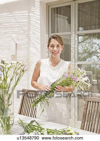 Woman arranging flowers in kitchen View Large Photo Image Stock Image - Woman arranging flowers in kitchen. Fotosearch