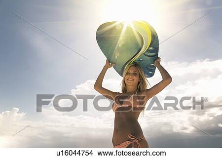 Woman carrying boogie board outdoors View Large Photo Image Picture - Woman carrying boogie board outdoors. Fotosearch