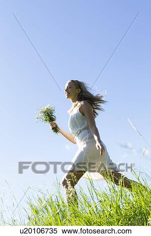 Woman carrying bouquet in tall grass View Large Photo Image Stock Photography - Woman carrying bouquet in tall grass. Fotosearch