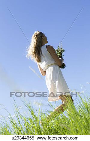 Woman carrying bouquet in tall grass View Large Photo Image Stock Photography - Woman carrying bouquet in tall grass. Fotosearch