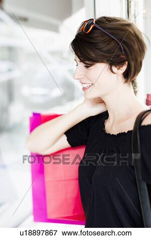 Woman carrying shopping on city street View Large Photo Image Stock Photo - Woman carrying shopping on city street. Fotosearch