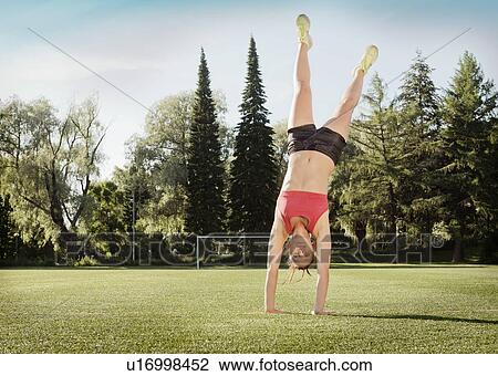 Woman doing cartwheel in park View Large Photo Image Stock Image - Woman doing cartwheel in park. Fotosearch