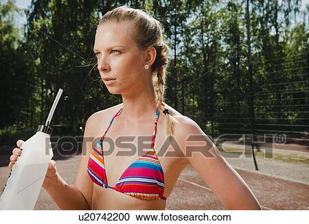 Woman drinking water on tennis court View Large Photo Image Stock Image - Woman drinking water on tennis court. Fotosearch