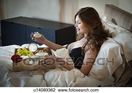 Woman eating breakfast in bed View Large Photo Image Stock Image - Woman eating breakfast in bed. Fotosearch