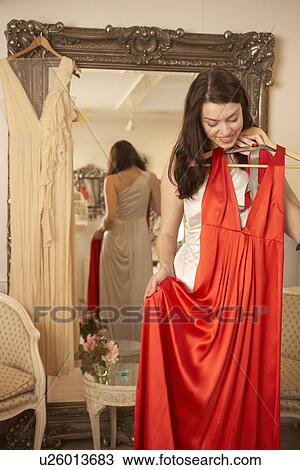 Woman examining dress in store View Large Photo Image Stock Image - Woman examining dress in store. Fotosearch
