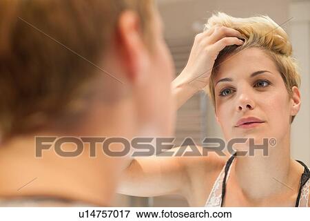 Woman examining herself in mirror View Large Photo Image Stock Photo - Woman examining herself in mirror. Fotosearch