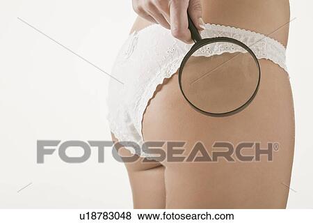Stock Photo - Woman examining herself with magnifier. Fotosearch