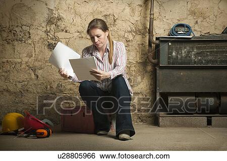 Stock Photograph - Woman examining papers indoors. Fotosearch