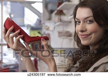 Woman examining shoe in store View Large Photo Image Stock Photo - Woman examining shoe in store. Fotosearch