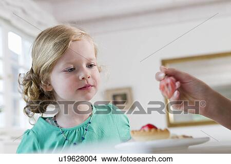 Woman feeding daughter breakfast View Large Photo Image Picture - Woman feeding daughter breakfast. Fotosearch