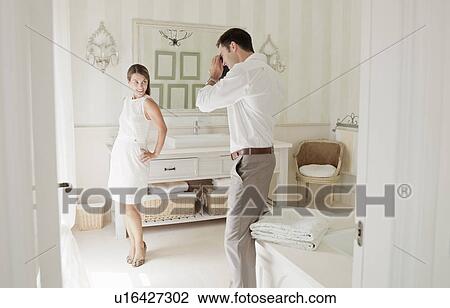 Stock Image - Woman having picture taken in bathroom. Fotosearch
