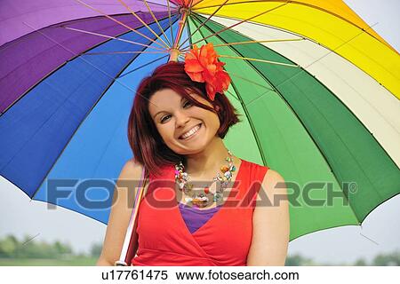 Woman holding colorful umbrella View Large Photo Image Stock Photography - Woman holding colorful umbrella. Fotosearch