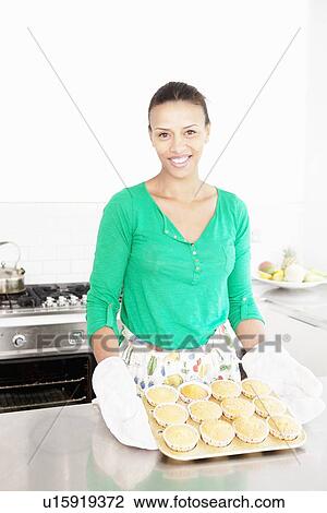 Woman holding tray of cupcakes View Large Photo Image Stock Image - Woman holding tray of cupcakes. Fotosearch