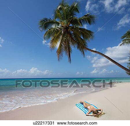 Woman laying on towel on beach View Large Photo Image Stock Image - Woman laying on towel on beach. Fotosearch