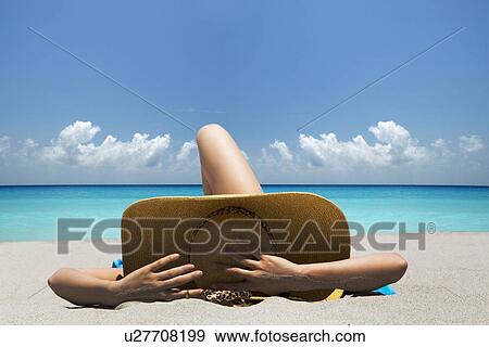 Woman laying on towel on beach View Large Photo Image Stock Photo - Woman laying on towel on beach. Fotosearch