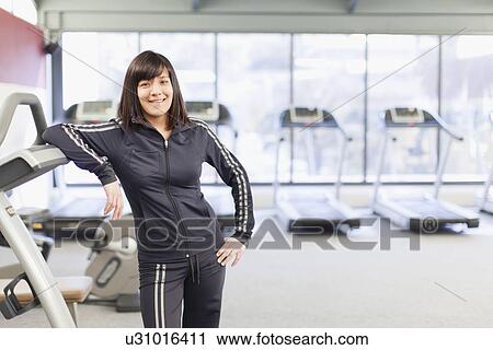Woman leaning on treadmill at gym View Large Photo Image Stock Image - Woman leaning on treadmill at gym. Fotosearch