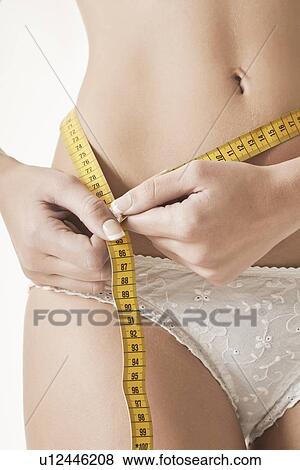 Stock Photo - Woman measuring her waistline. Fotosearch