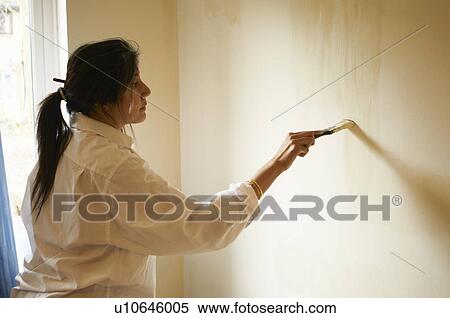 Woman painting room with paintbrush View Large Photo Image Stock Photography - Woman painting room with paintbrush. Fotosearch