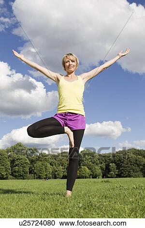 Woman practicing yoga in park View Large Photo Image Stock Image - Woman practicing yoga in park. Fotosearch