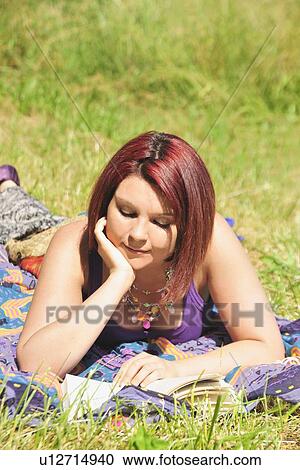 Woman reading book in grass View Large Photo Image Stock Image - Woman reading book in grass. Fotosearch