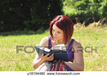 Woman reading book in grass View Large Photo Image Stock Image - Woman reading book in grass. Fotosearch