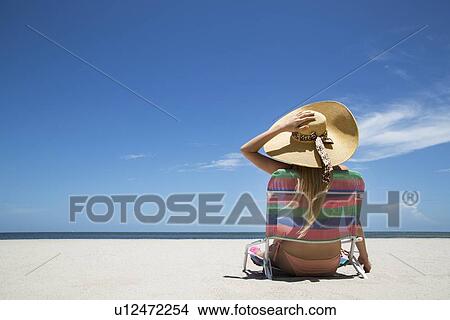 Woman relaxing in lawn chair on beach View Large Photo Image Picture - Woman relaxing in lawn chair on beach. Fotosearch