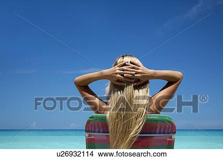 Woman relaxing in lawn chair on beach View Large Photo Image Picture - Woman relaxing in lawn chair on beach. Fotosearch