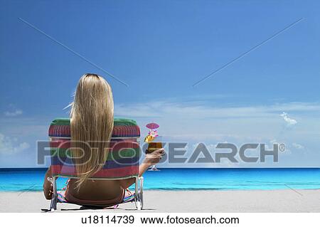 Woman relaxing in lawn chair on beach View Large Photo Image Stock Photo - Woman relaxing in lawn chair on beach. Fotosearch