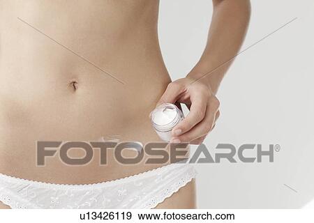 Woman rubbing lotion on belly View Large Photo Image Stock Photo - Woman rubbing lotion on belly. Fotosearch