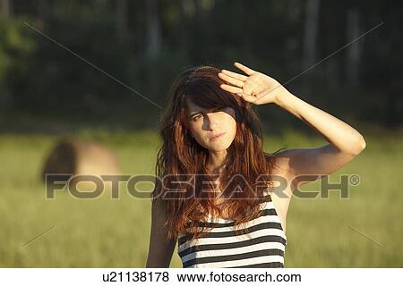 Woman shielding her eyes from sun View Large Photo Image Stock Photo - Woman shielding her eyes from sun. Fotosearch