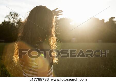 Woman shielding her eyes from sun View Large Photo Image Stock Photograph - Woman shielding her eyes from sun. Fotosearch